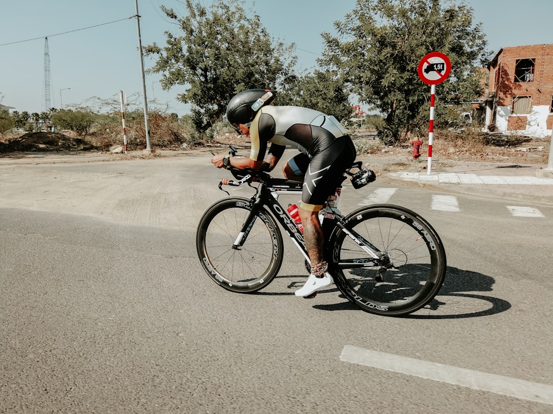 Close-up of a cyclist pedaling on a road bike with a power meter visible.
