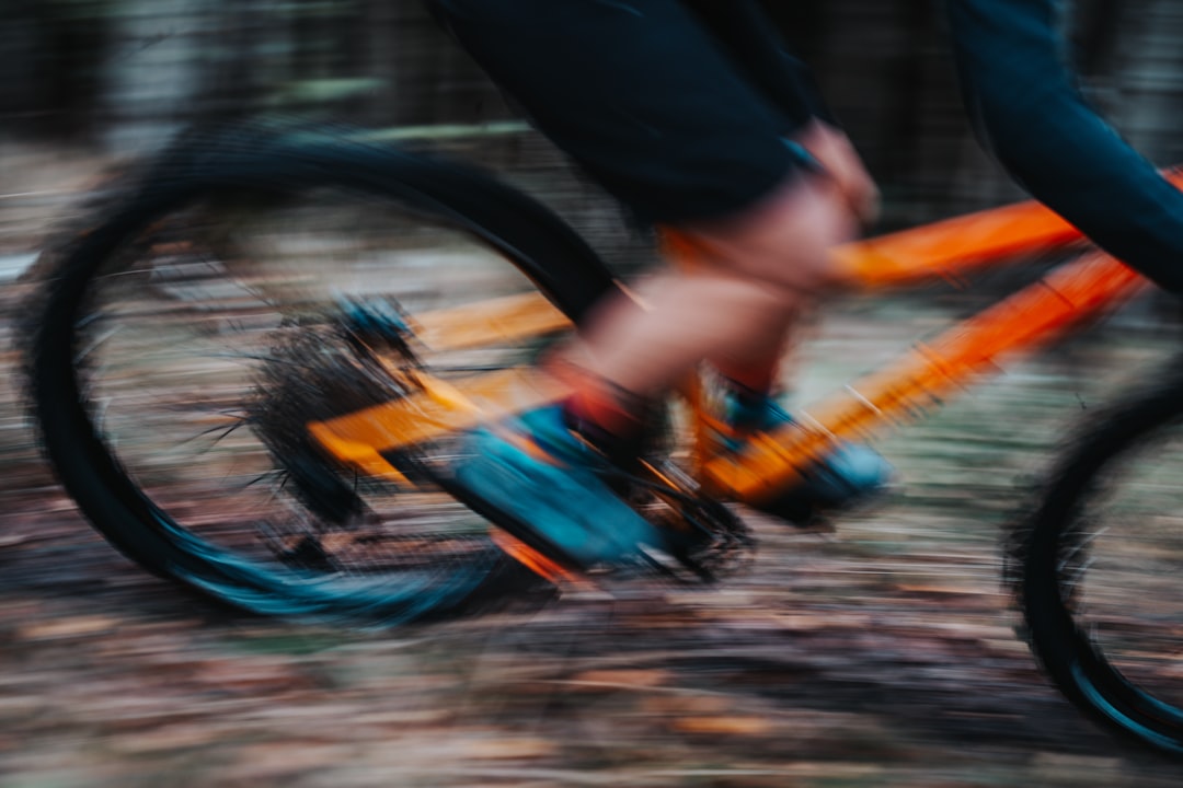 Close-up of a cyclist pedaling on a road bike with a power meter visible.