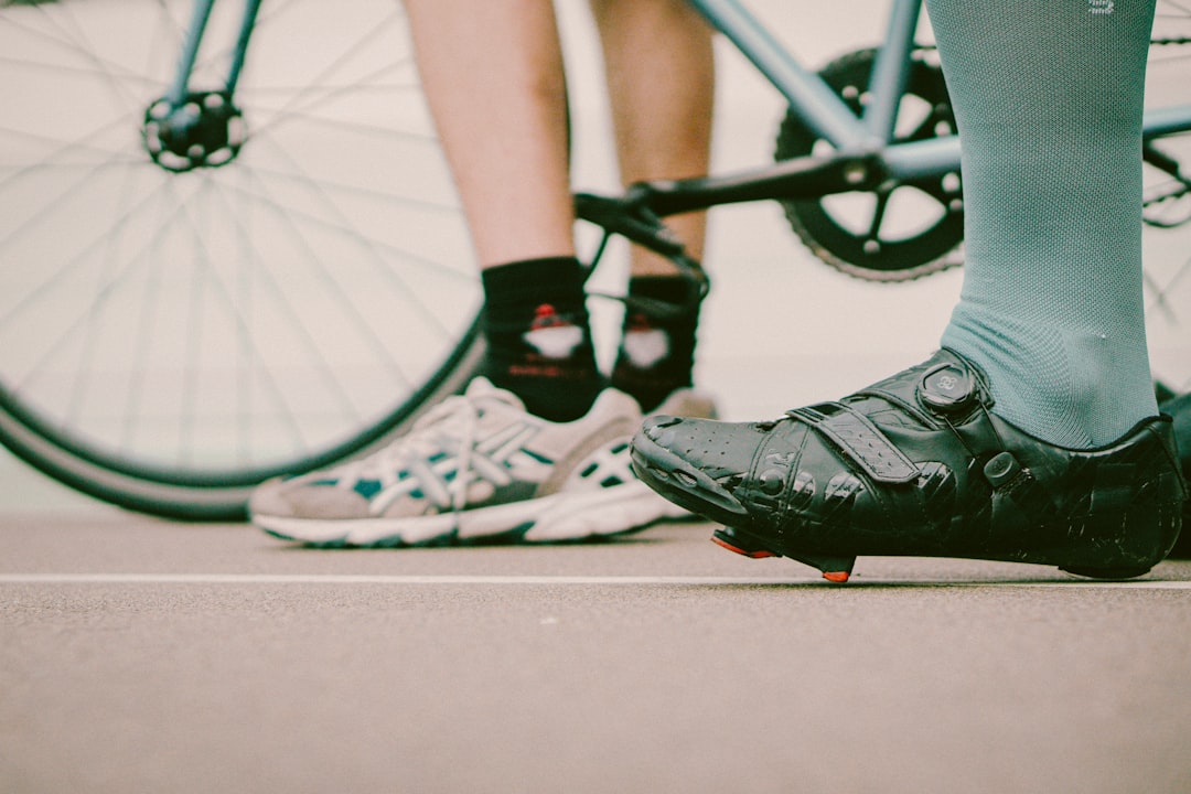 Close-up of a cyclist pedaling on a road bike with a power meter visible.