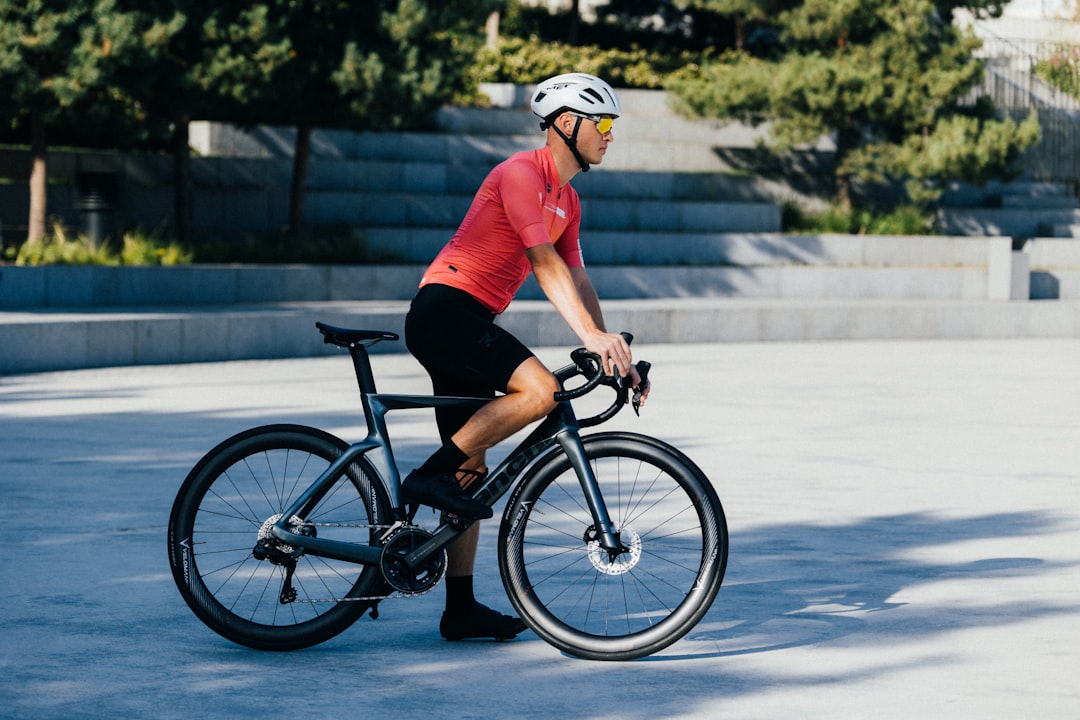 Close-up of a cyclist pedaling on a road bike with a power meter visible.