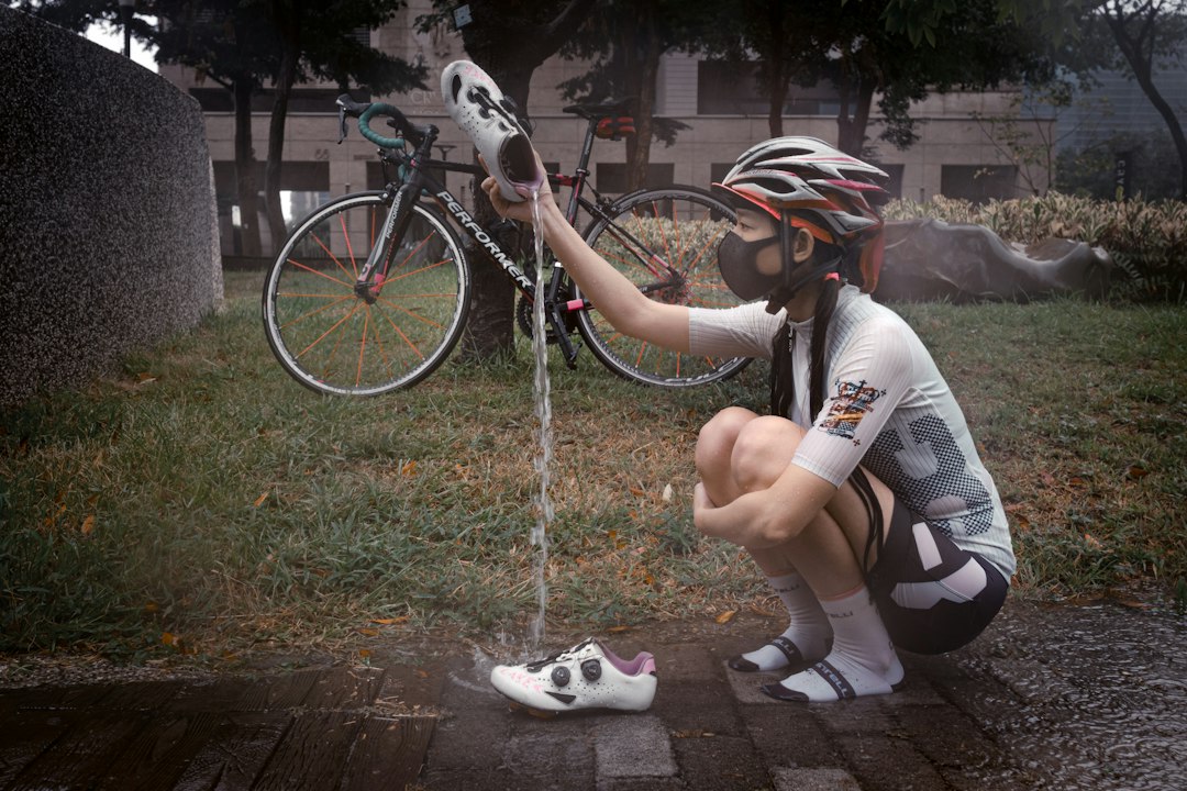 Close-up of a cyclist pedaling on a road bike with a power meter visible.