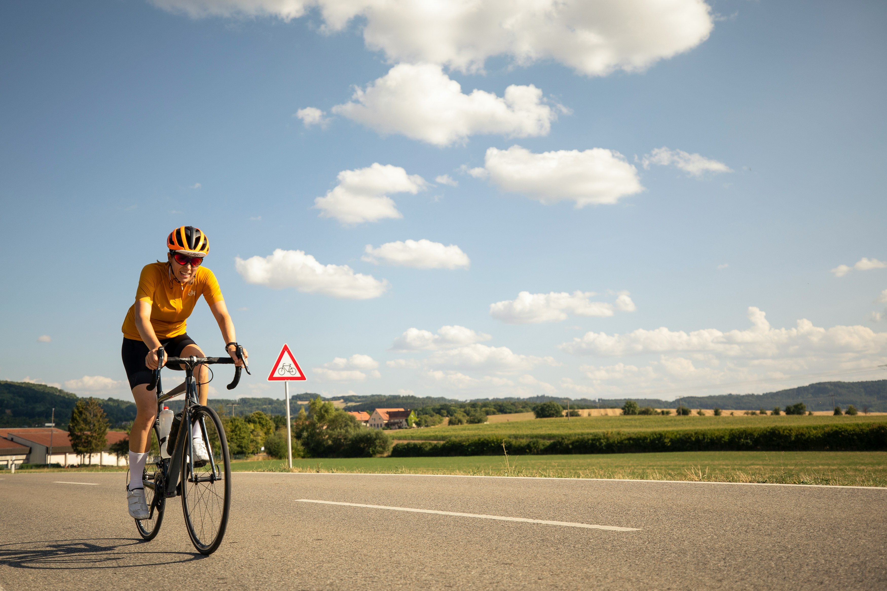 Cyclist riding a road bike outdoors in real conditions.