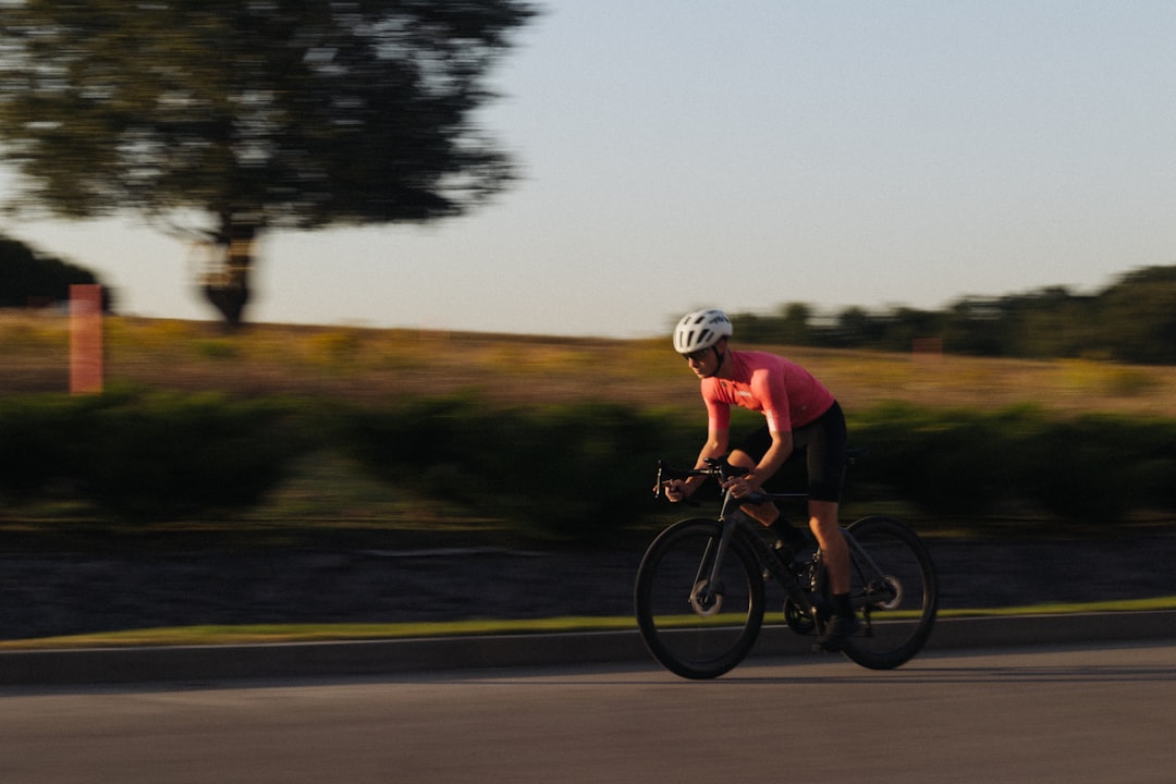 Close-up of a cyclist pedaling on a road bike with a power meter visible.