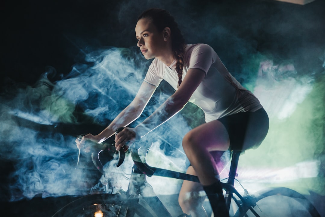 Close-up of a cyclist pedaling on a road bike with a power meter visible.