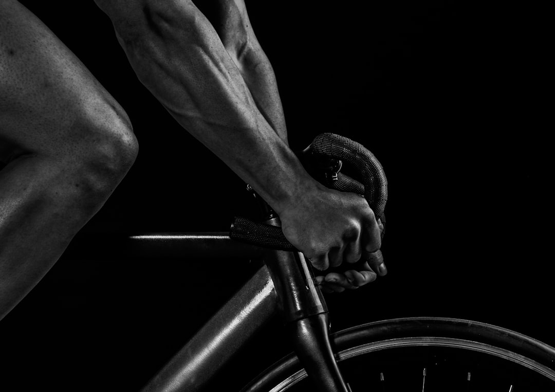 Close-up of a cyclist pedaling on a road bike with a power meter visible.