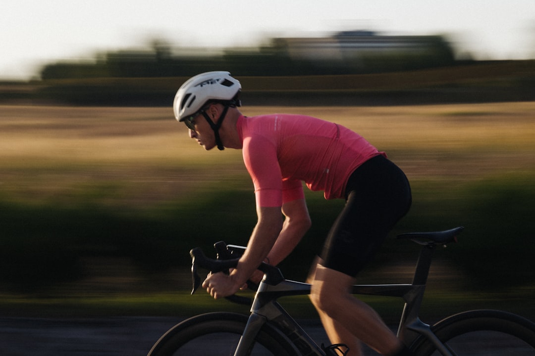 Close-up of a cyclist pedaling on a road bike with a power meter visible.