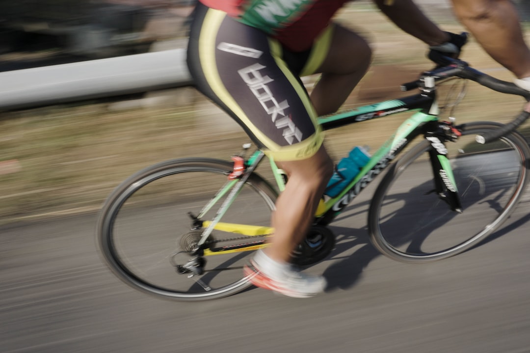 Close-up of a cyclist pedaling on a road bike with a power meter visible.