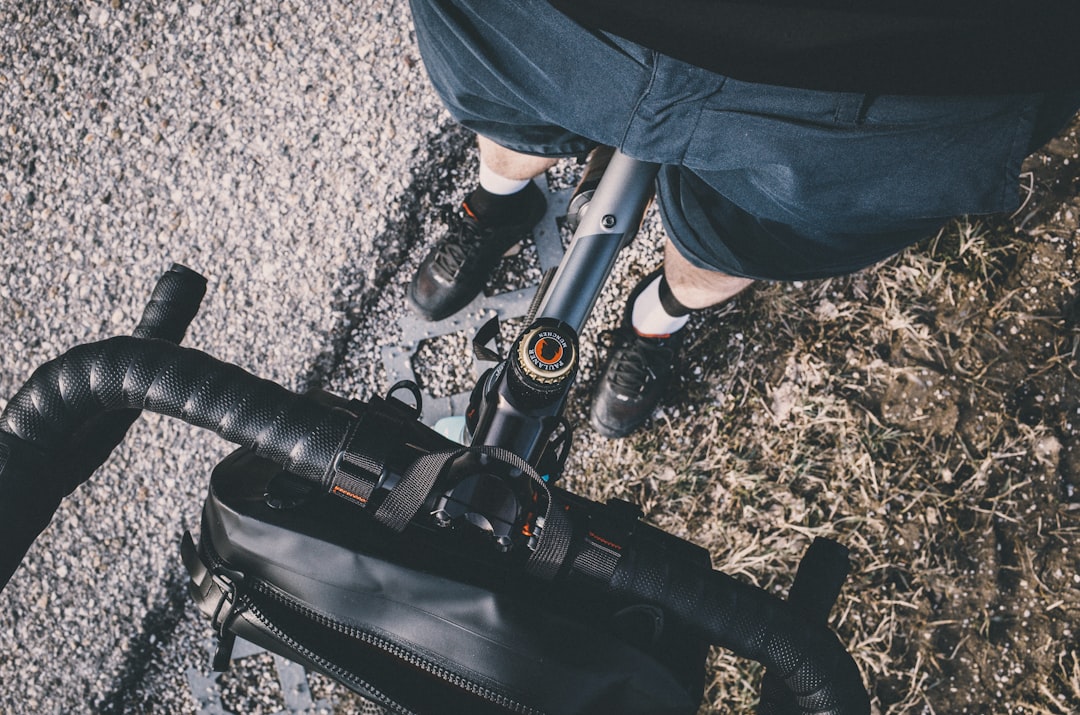 Close-up of a cyclist pedaling on a road bike with a power meter visible.