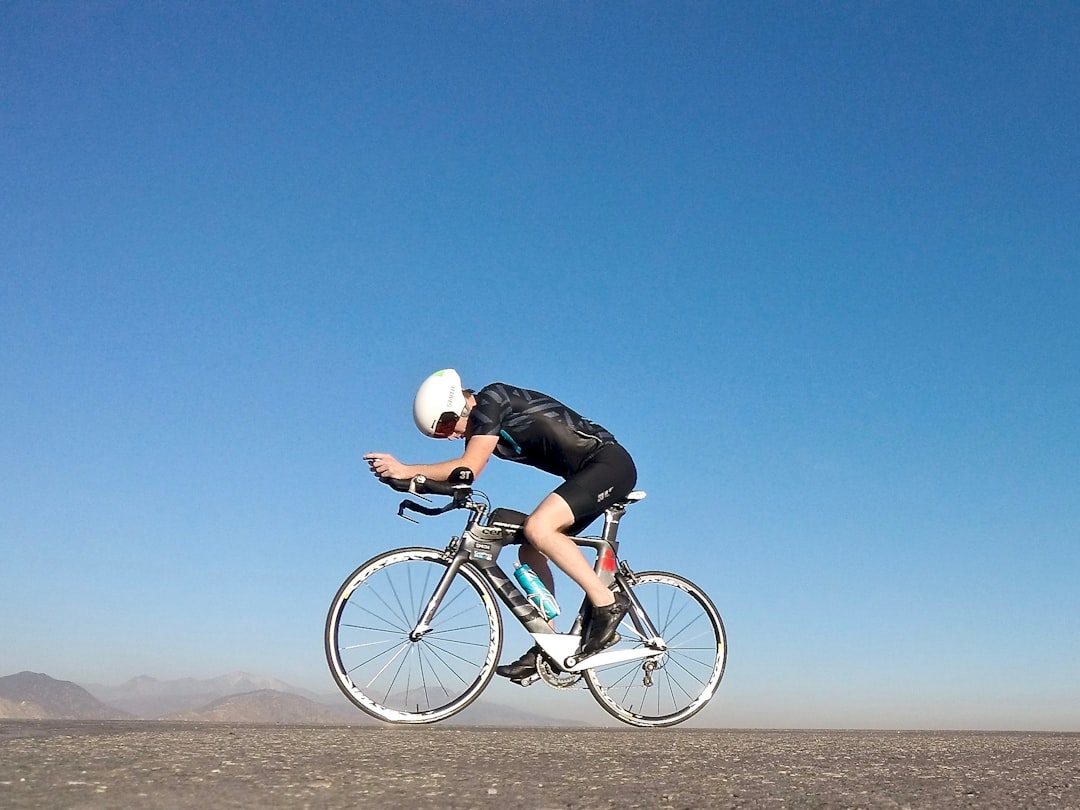 Close-up of a cyclist pedaling on a road bike with a power meter visible.