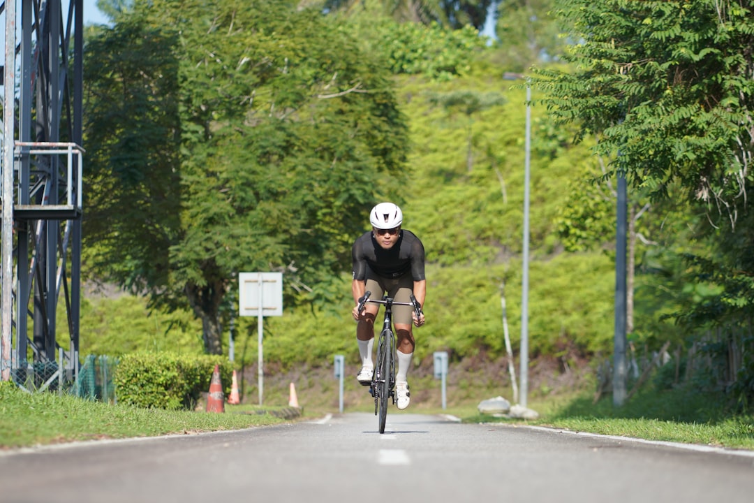 Close-up of a cyclist pedaling on a road bike with a power meter visible.