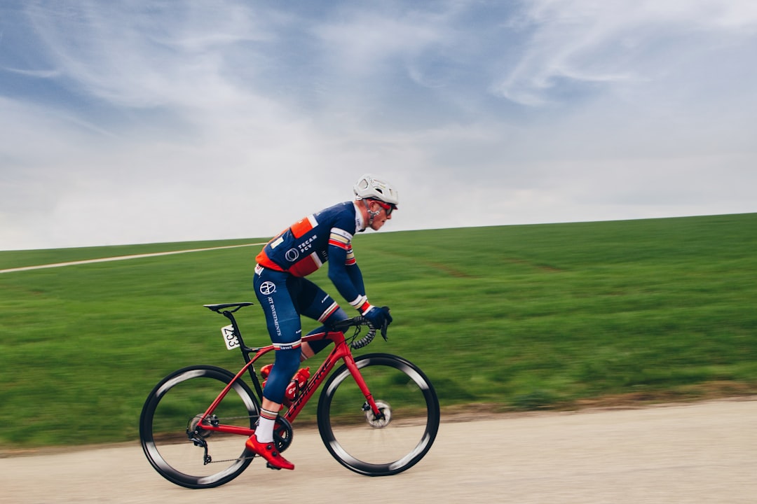 Close-up of a cyclist pedaling on a road bike with a power meter visible.