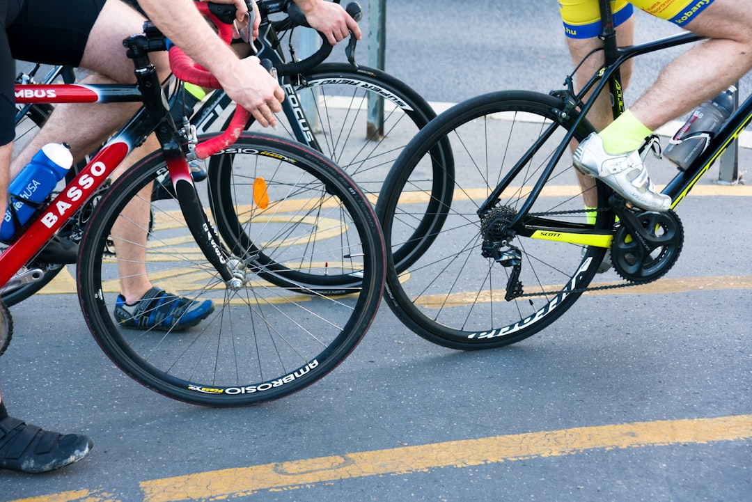 Close-up of a cyclist pedaling on a road bike with a power meter visible.
