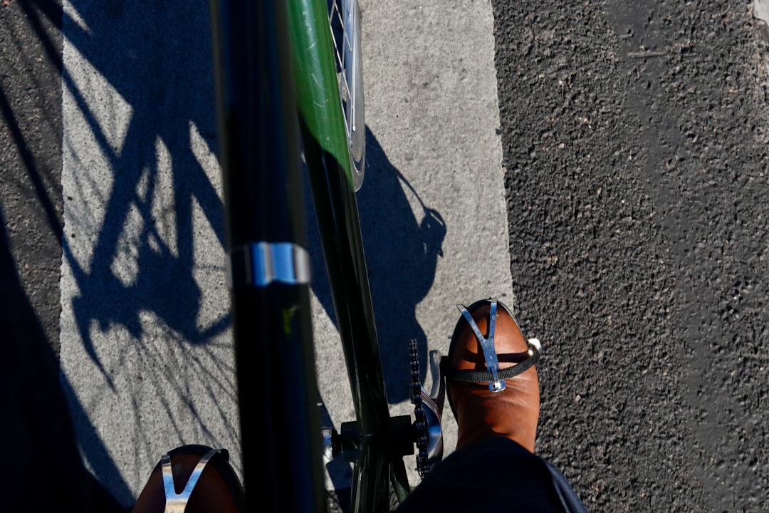 Close-up of a cyclist pedaling on a road bike with a power meter visible.