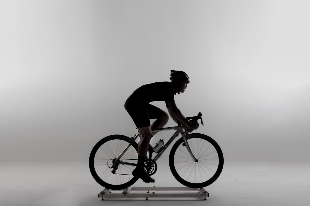 Close-up of a cyclist pedaling on a road bike with a power meter visible.