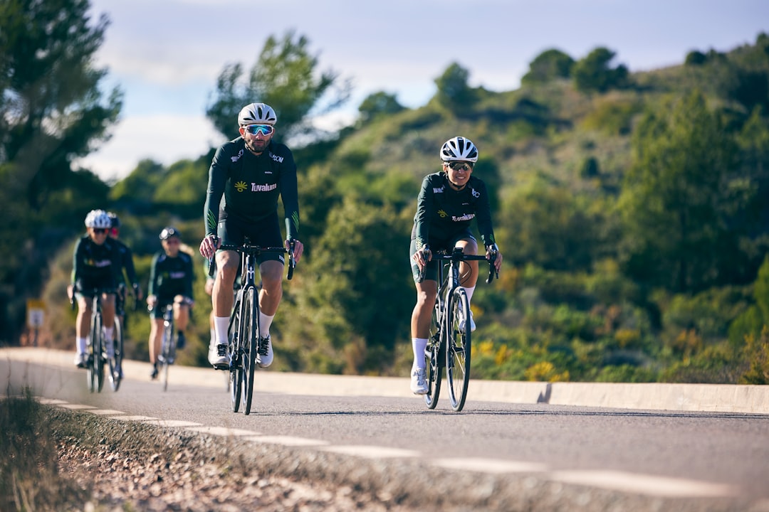 Group of road cyclists riding together outdoors on paved roads.