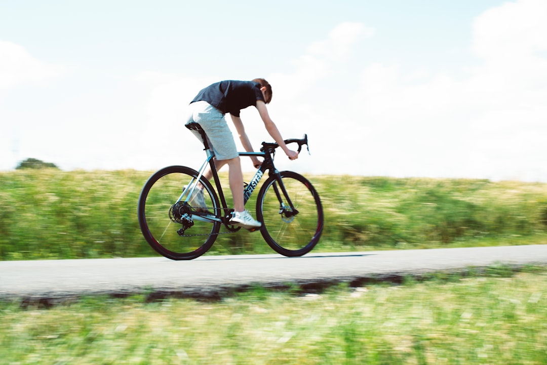 Close-up of a cyclist pedaling on a road bike with a power meter visible.