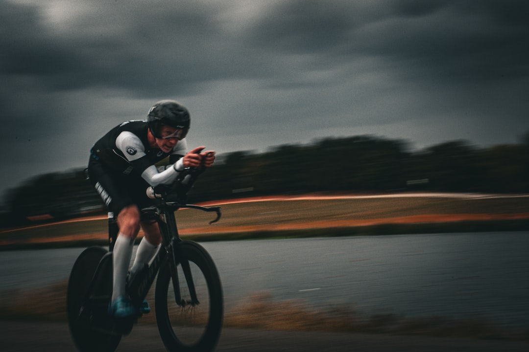 Close-up of a cyclist pedaling on a road bike with a power meter visible.