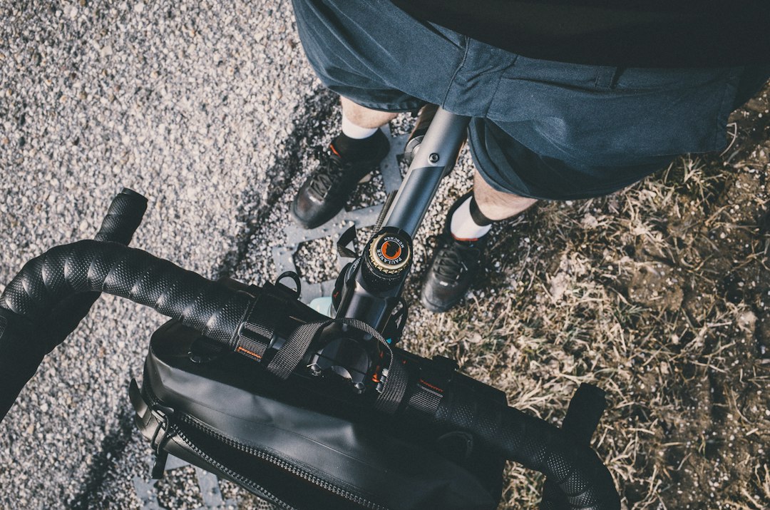 Close-up of a cyclist pedaling on a road bike with a power meter visible.