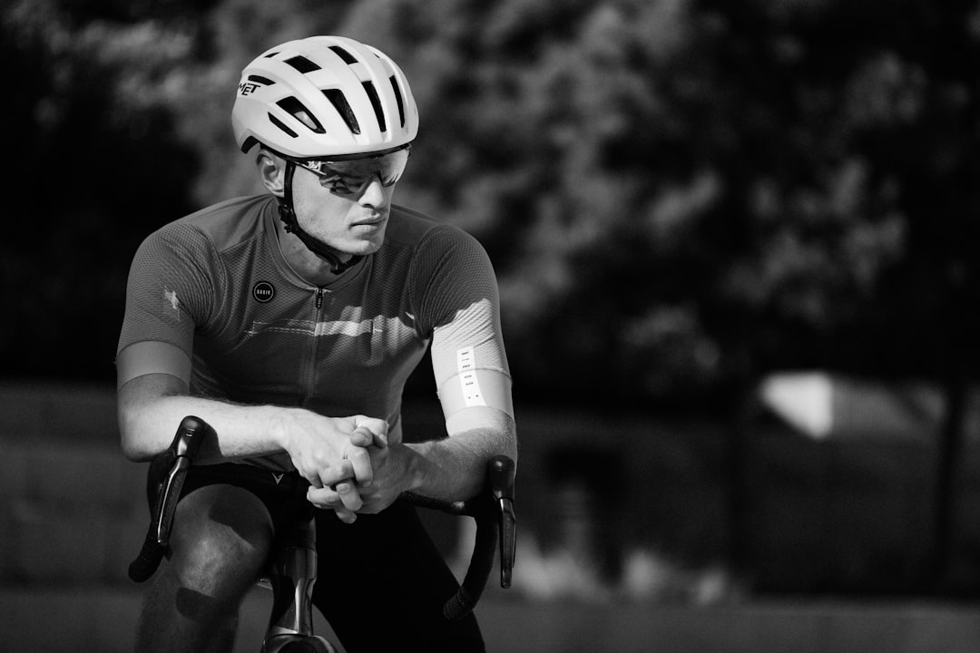 Close-up of a cyclist pedaling on a road bike with a power meter visible.