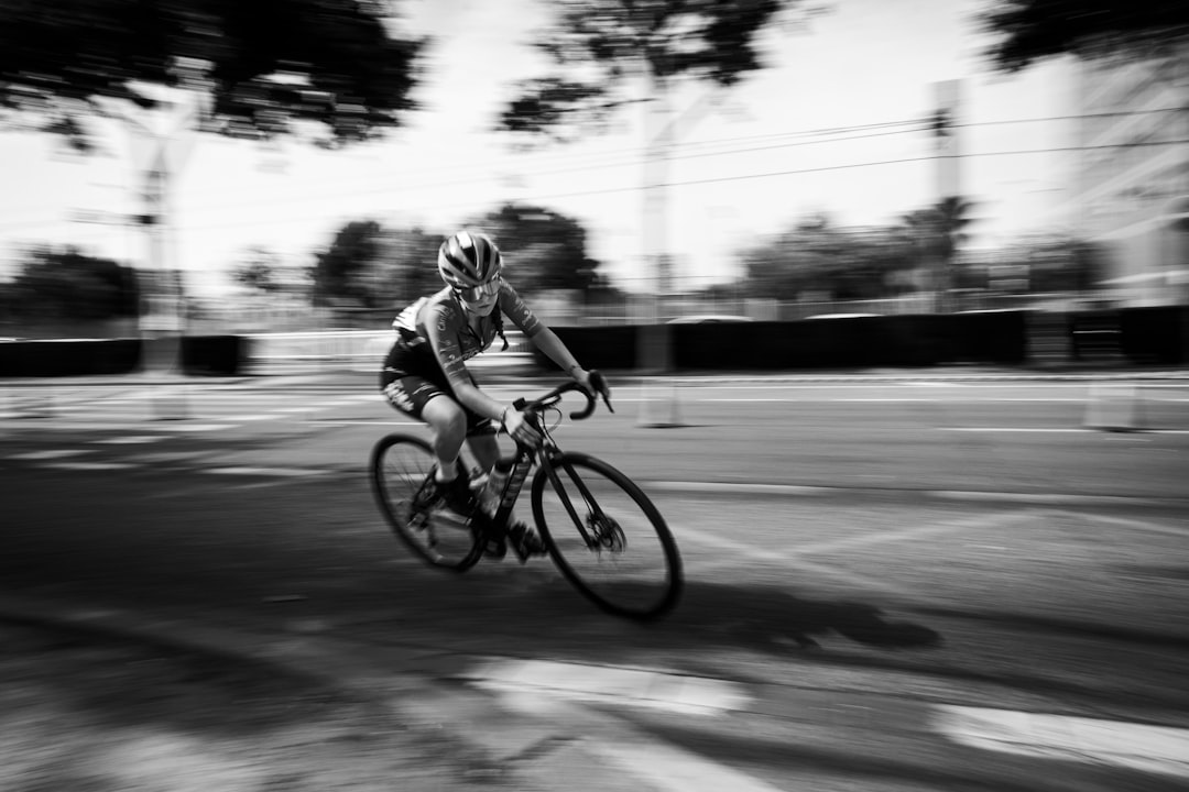Close-up of a cyclist pedaling on a road bike with a power meter visible.
