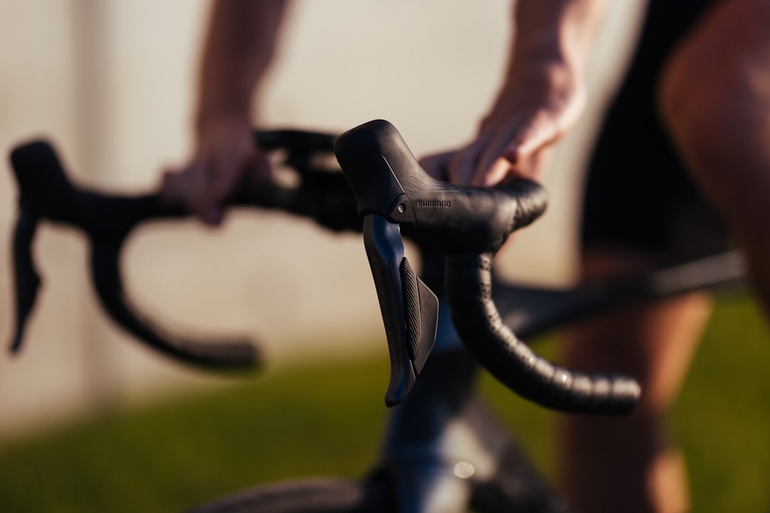 Close-up of a cyclist pedaling on a road bike with a power meter visible.