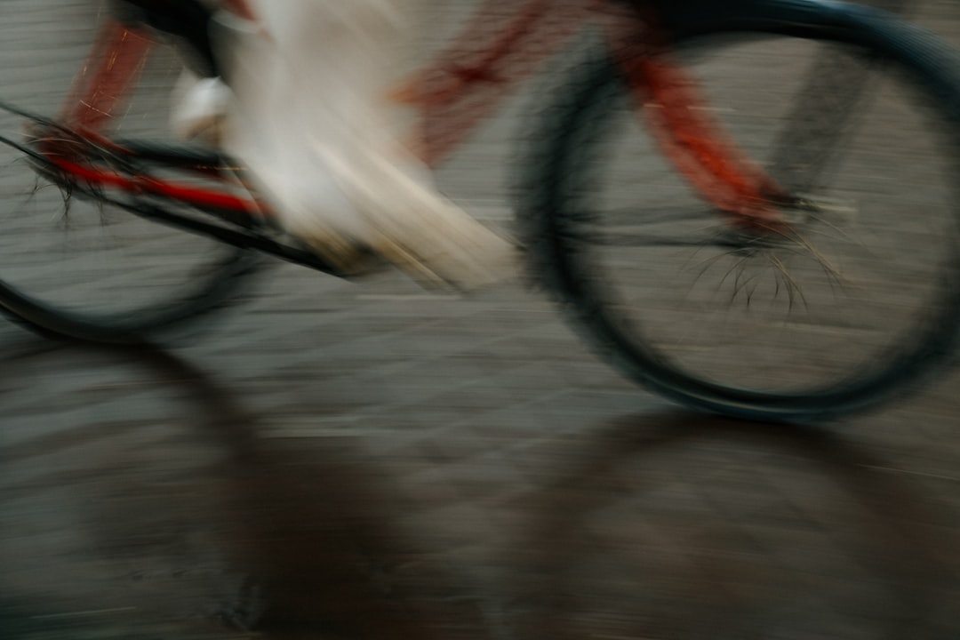 Close-up of a cyclist pedaling on a road bike with a power meter visible.