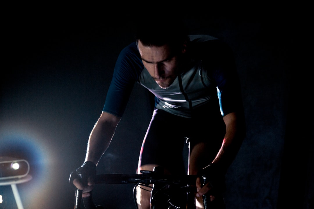 Close-up of a cyclist pedaling on a road bike with a power meter visible.