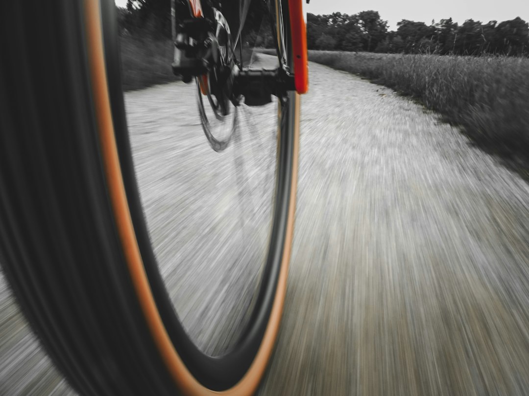 Close-up of a cyclist pedaling on a road bike with a power meter visible.