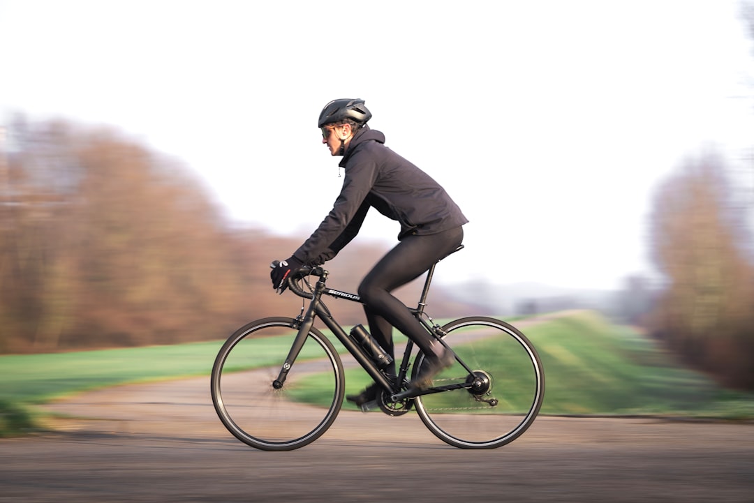 Close-up of a cyclist pedaling on a road bike with a power meter visible.