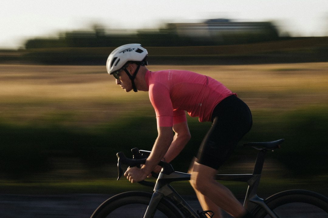 Close-up of a cyclist pedaling on a road bike with a power meter visible.