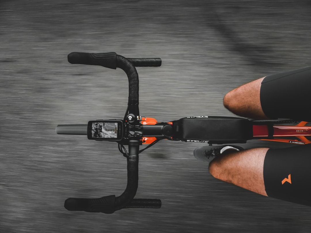 Close-up of a cyclist pedaling on a road bike with a power meter visible.