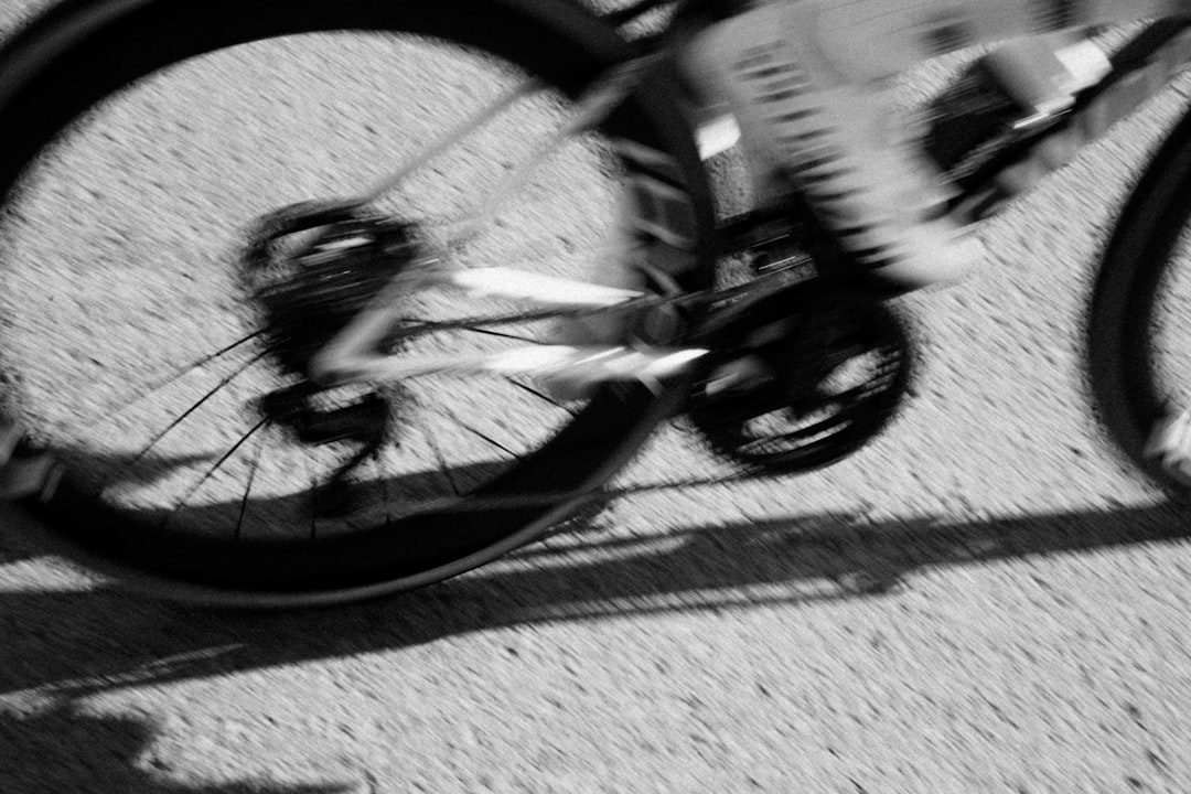 Close-up of a cyclist pedaling on a road bike with a power meter visible.