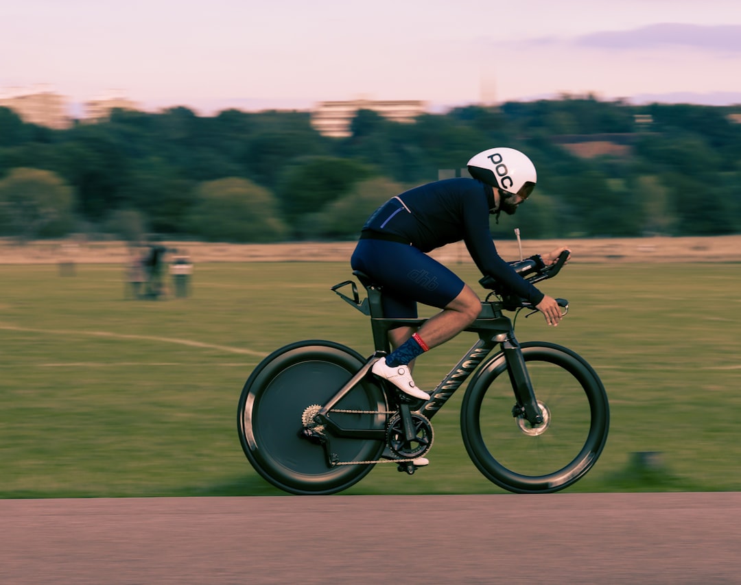Close-up of a cyclist pedaling on a road bike with a power meter visible.