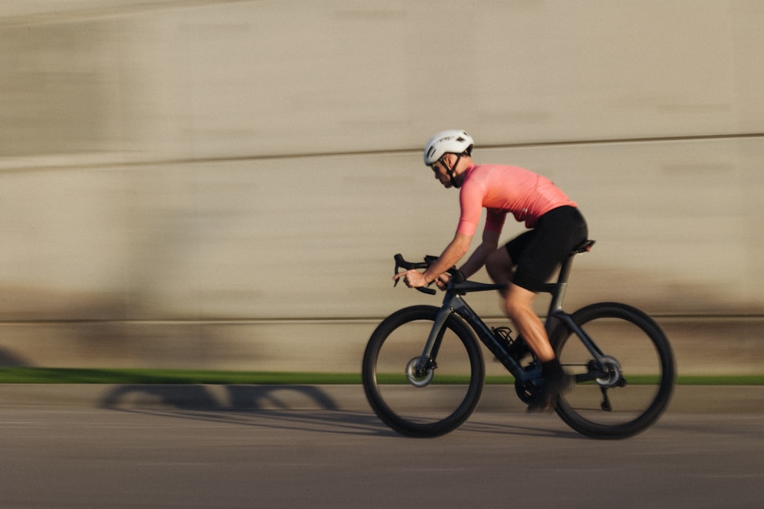 Close-up of a cyclist pedaling on a road bike with a power meter visible.