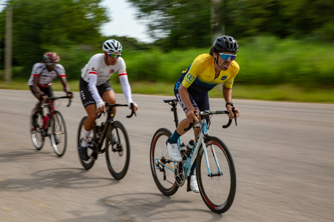 Close-up of a cyclist pedaling on a road bike with a power meter visible.