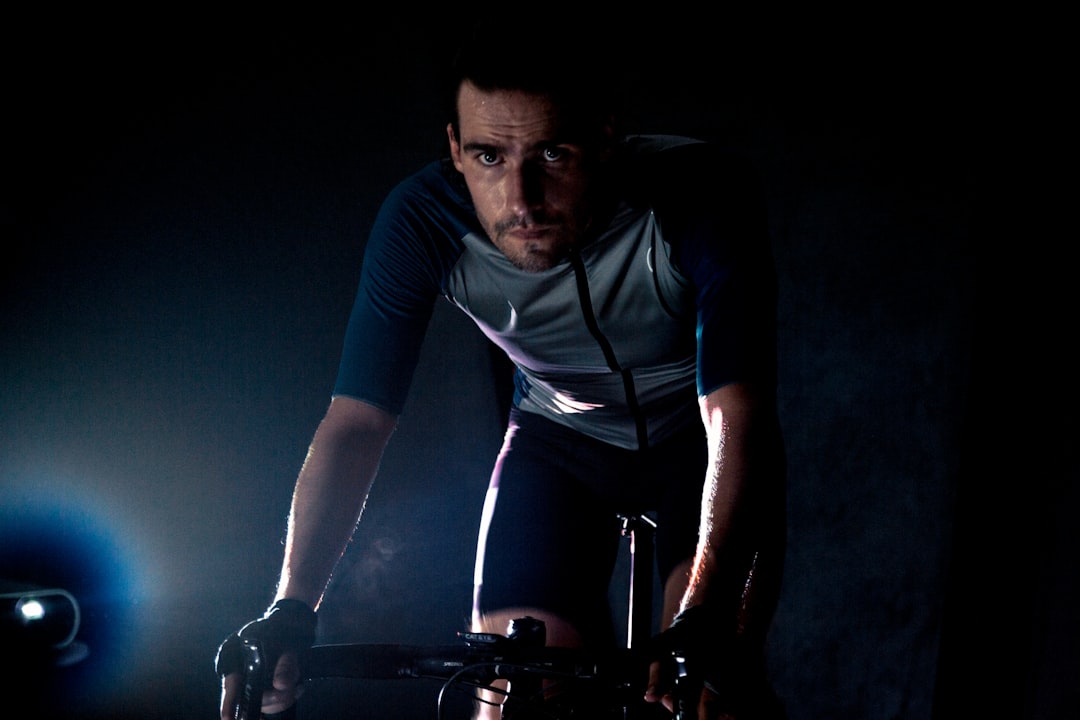 Close-up of a cyclist pedaling on a road bike with a power meter visible.