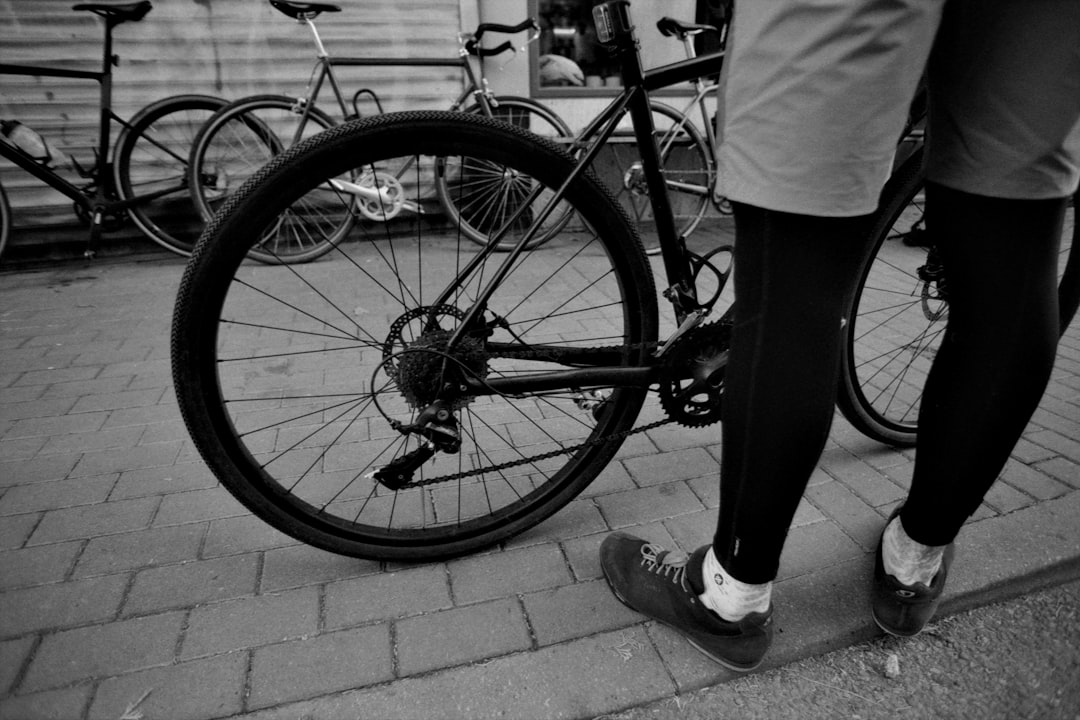 Close-up of a cyclist pedaling on a road bike with a power meter visible.