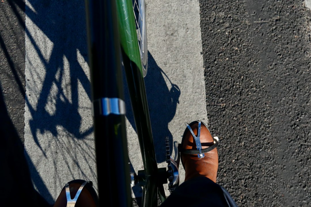 Close-up of a cyclist pedaling on a road bike with a power meter visible.