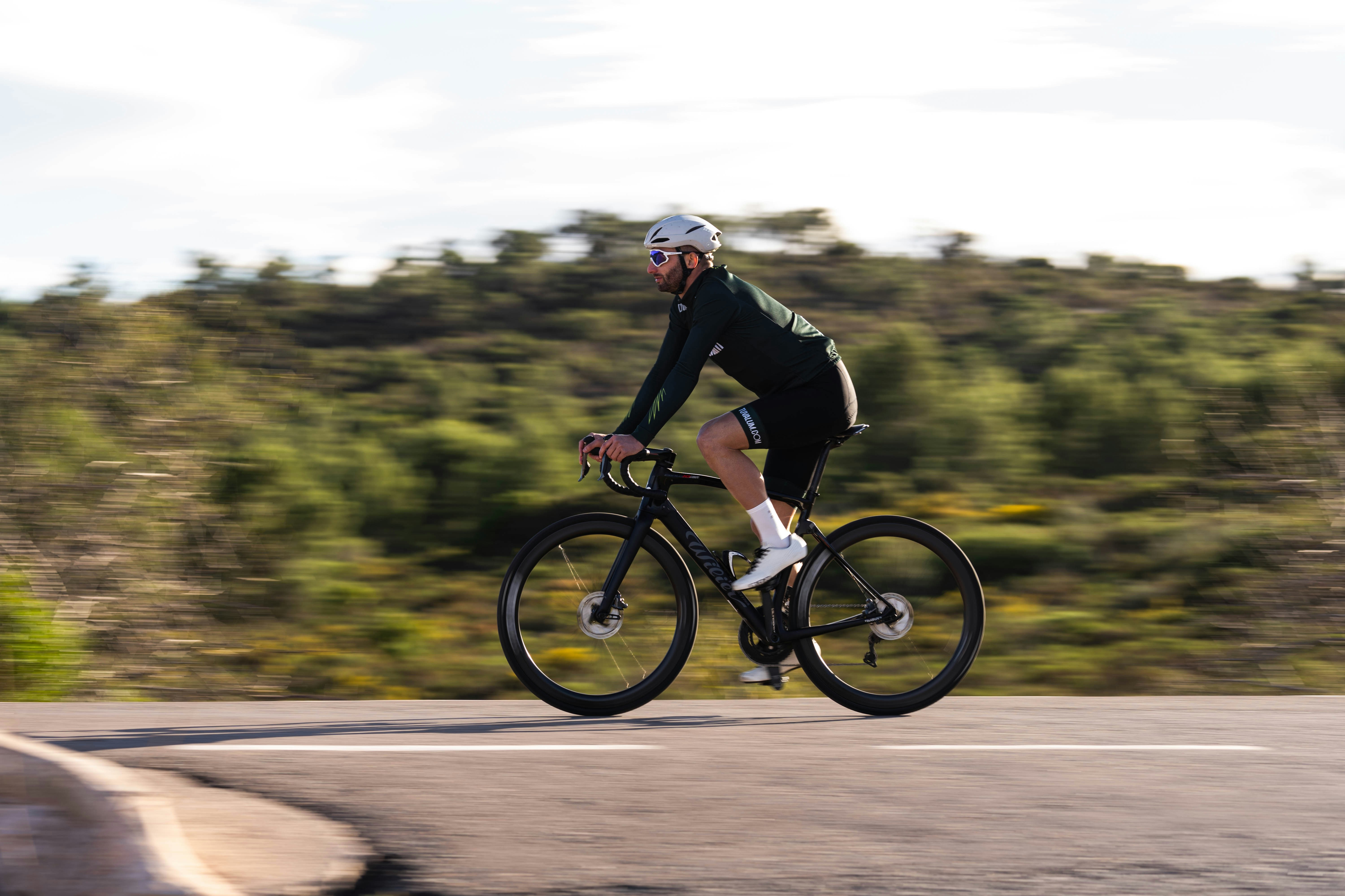 Cyclist riding a road bike outdoors in real conditions.
