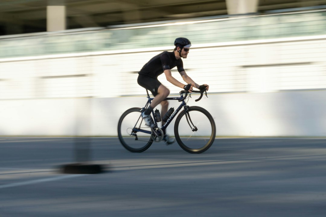 Close-up of a cyclist pedaling on a road bike with a power meter visible.